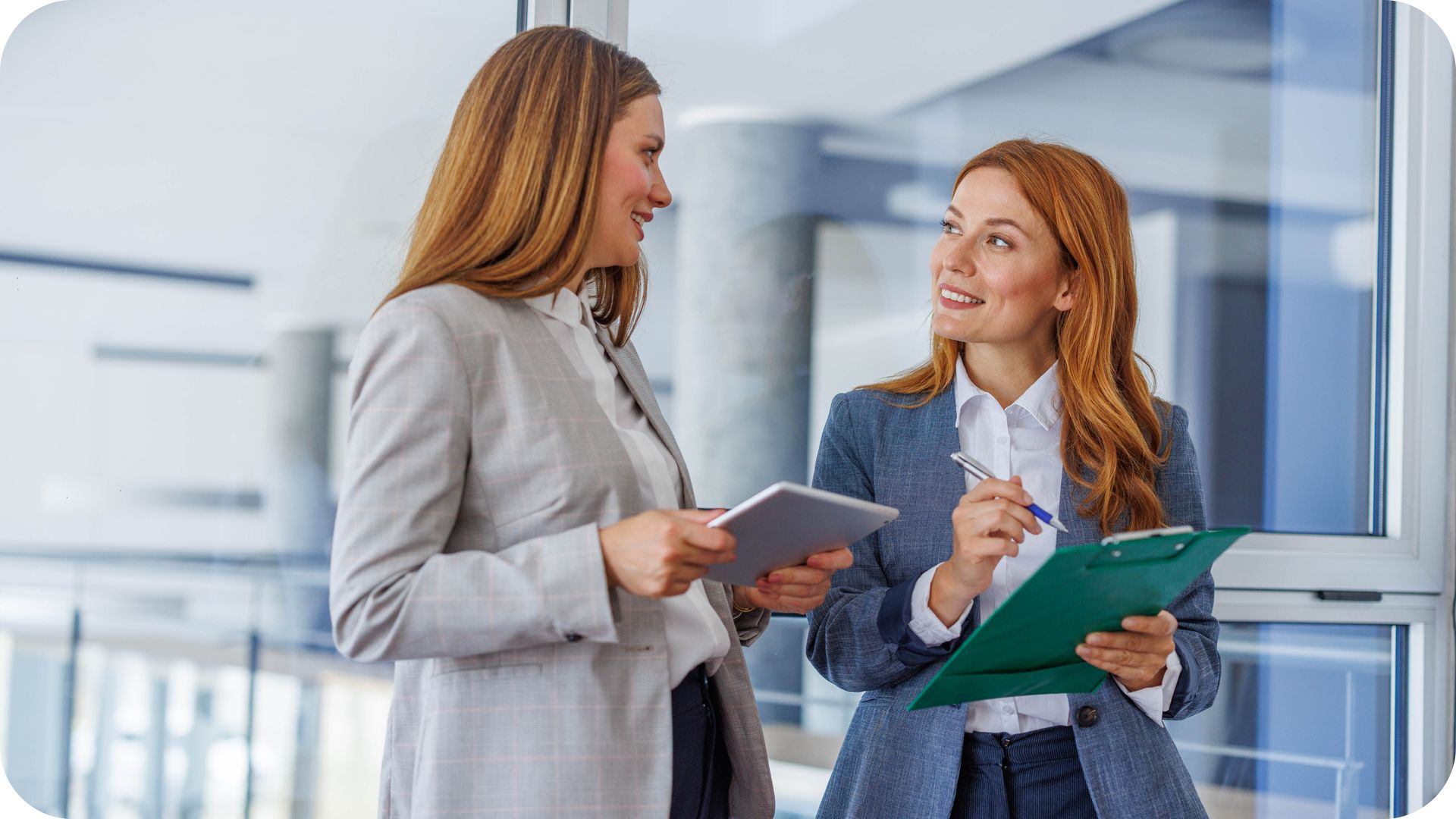 Zwei Geschäftsfrauen besprechen digitale Inhalte und Dokumente im Büro