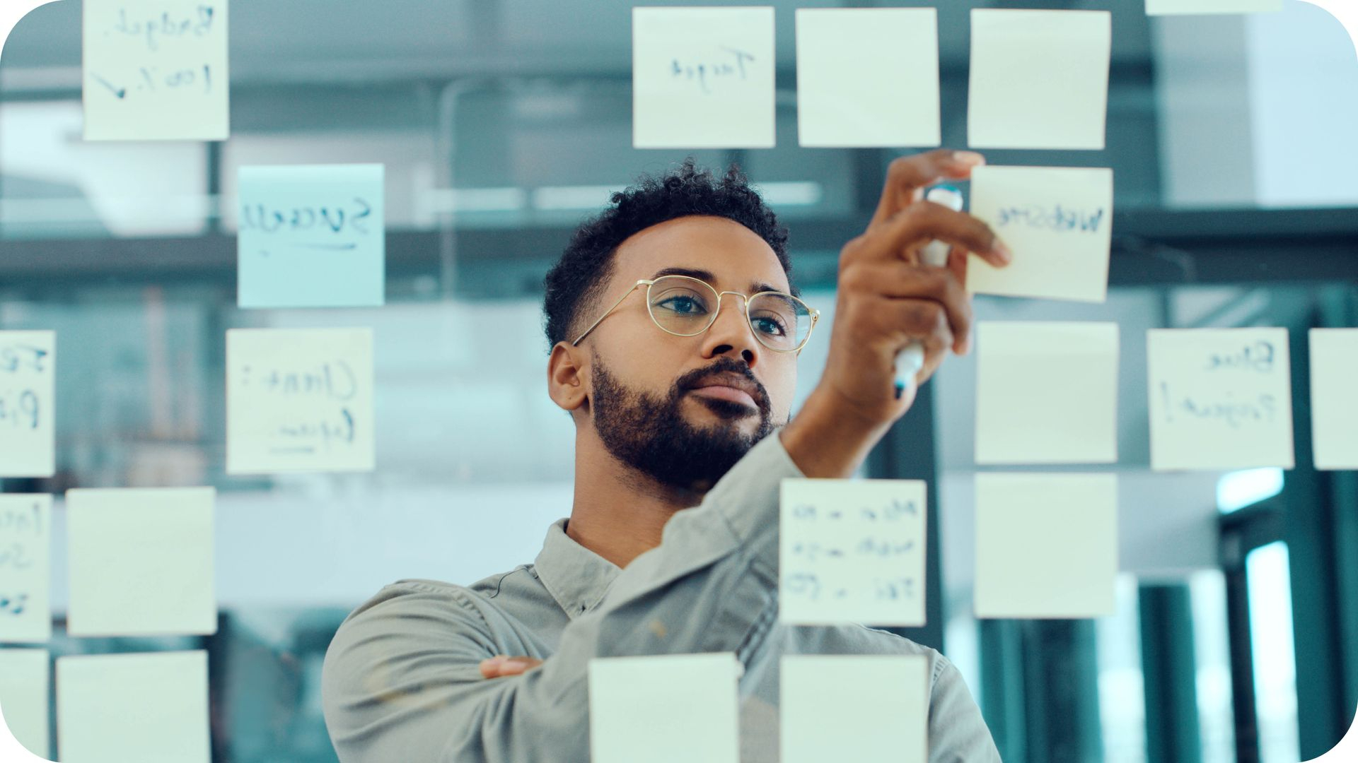AI Engineer strukturiert Ideen und Prozesse mit Haftnotizen an einer Glaswand